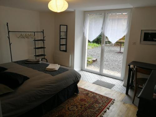 1 dormitorio con 1 cama y puerta corredera de cristal en La maison du Sotré en Raon-sur-Plaine