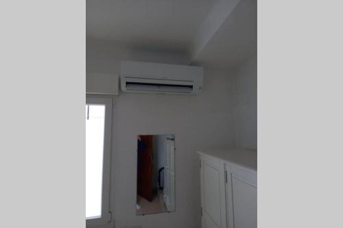 a white kitchen with a window and a refrigerator at Empuriabrava 500m de la plage de la Rubina in Empuriabrava