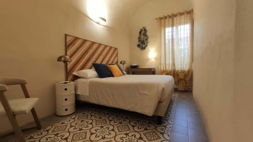 een slaapkamer met een bed, een stoel en een raam bij Lo Strullo in Pisa
