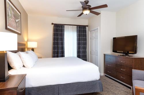 een slaapkamer met een bed en een flatscreen-tv bij Club Wyndham Mountain Vista in Branson