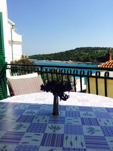 a table with a vase with flowers on a balcony at House Klarin in Jezera
