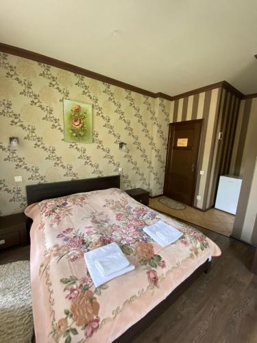 a bedroom with a bed with two towels on it at Приватна садиба Європа in Solochin