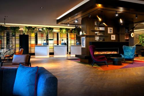 a living room filled with furniture and a large window at Leonardo Royal Hotel London City - Tower of London in London