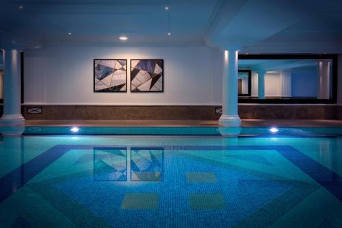 a swimming pool in a building at night at Leonardo Royal Hotel London City - Tower of London in London