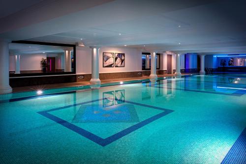 a large swimming pool in a hotel room at Leonardo Royal Hotel London City - Tower of London in London