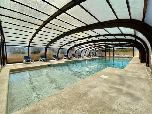 une piscine intérieure avec des chaises et une grande piscine d'eau dans l'établissement Hotel Myriam Vias Plage, à Vias