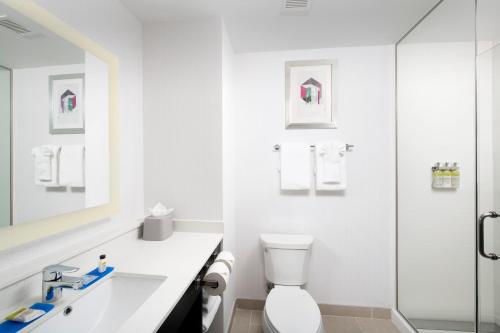 a white bathroom with a toilet and a shower at Holiday Inn Express Pensacola Downtown, an IHG Hotel in Pensacola