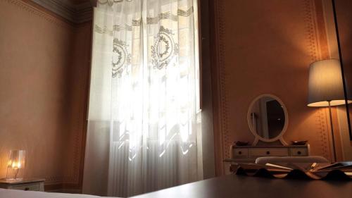 a bedroom with a window with a white curtain at Lo Strullo in Pisa