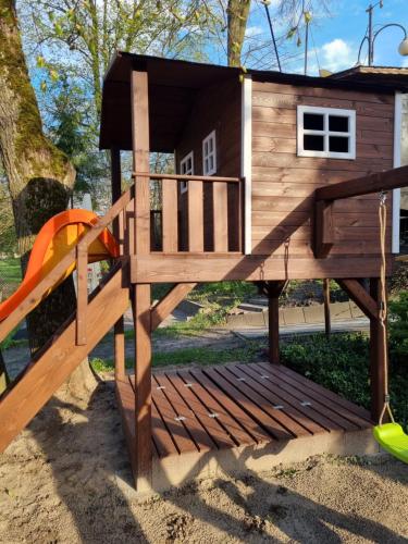 a playground with a tree house and a slide at Karczma Regionalna Młyn -pokoje gościne in Zwierzyniec