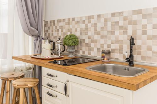 a kitchen with a sink and a counter with stools at ALBERT RESIDENCE Aparthotel in Braşov