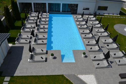 ein Pool mit Chaiselongue und ein paar Liegestützen in der Unterkunft Krystal Boutique Mansion in Hunedoara