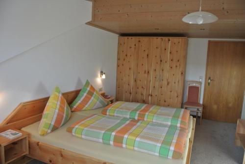 a bedroom with a bed with a wooden headboard at Ferienwohnung Breyer, südliches Allgäu in Hopferau