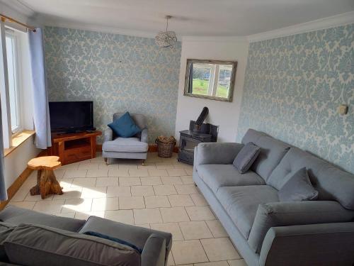 a living room with a couch and a tv at Ard Na Mara Self Catering Isle of Mull in Dervaig