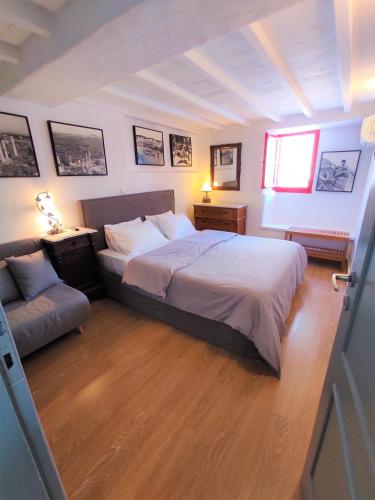 a bedroom with a large bed and a couch at Bougainvillea Typical Town House - Private Rooftop in Mikonos