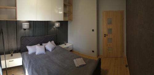 um quarto com uma cama com almofadas brancas em Apartament Malta Poznań em Poznań