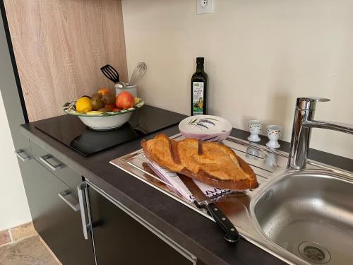 - un évier avec un pain et un bol de fruits dans l'établissement Paradis de Provence, Wohnungen, à Le Pin