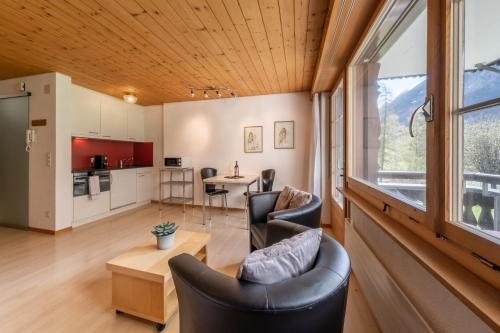 een woonkamer met een bank, stoelen en een tafel bij Quadernpark-Apartments in Valens
