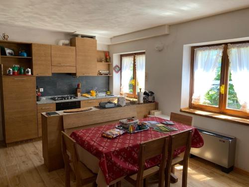 eine Küche mit einem Tisch und einem roten Tischtuch in der Unterkunft Appartamento Tapì in Passo del Tonale