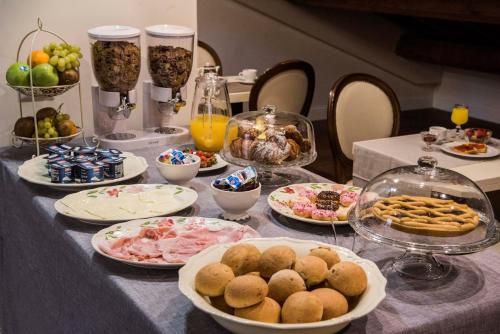 a table topped with plates of food and drinks at Hotel San Silvestro in Rome