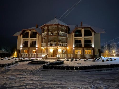 a large building in the snow at night at Приватна садиба Європа in Solochin