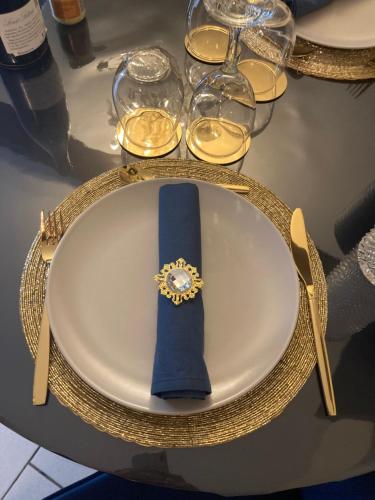 une table avec une plaque avec un ruban bleu et des verres dans l'établissement LE TOUT JOLI NID BEAUNOIS, Studio Plein centre parking, à Beaune