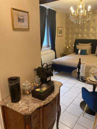 ein Hotelzimmer mit einem Bett und einem Tisch mit einem Tisch in der Unterkunft LE TOUT JOLI NID BEAUNOIS, Studio Plein centre parking in Beaune