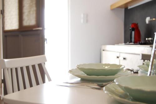 a table with bowls and plates on it in a kitchen at Galini Rooms & Apartments in Finikas
