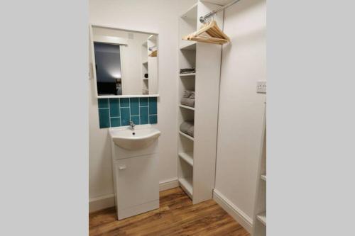 a bathroom with a sink and a mirror at Stylish studio bungalow, close to Cardiff Centre in Cardiff