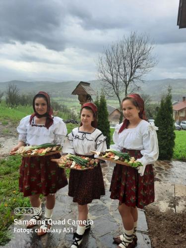 three girls are holding a tray of food at Pensiunea Valea Branzei in Năneşti