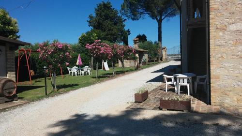 a street with tables and chairs in a yard with flowers at B&B Il Cascinale in Bettona