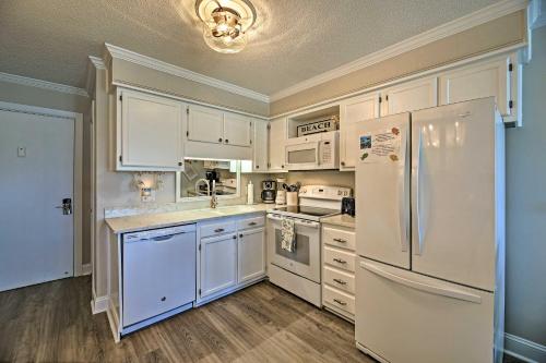 a kitchen with white appliances and white cabinets at Walk to Beach Ocean-View Atlantic Beach Condo! in Atlantic Beach