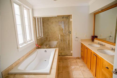 a bathroom with a tub and two sinks and a shower at Villa Renaissance Unit 205 Grace Bay Beach in Grace Bay