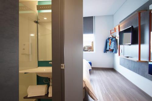 um quarto com uma cama, um lavatório e um espelho em ibis budget Bogota Marly em Bogotá