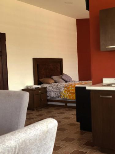 a bedroom with a bed and a table and chairs at Departamentos Bonsai in Torreón