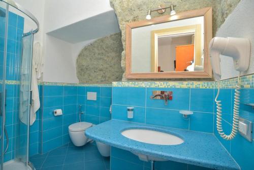 a blue bathroom with a sink and a mirror at Hotel Villa Cimmentorosso in Ischia