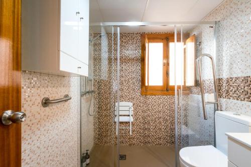 baño con ducha y puerta de cristal en Holi-Rent Estrella, en Sevilla