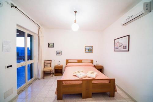 a bedroom with a bed and a large window at Hotel Villa Cimmentorosso in Ischia