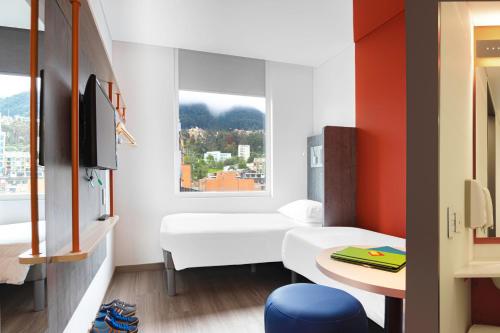 a small room with a bed and a window at ibis budget Bogota Marly in Bogotá