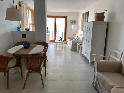 uma sala de estar com mesa e cadeiras em Port Pollensa Pins Apartment sea view em Port de Pollensa