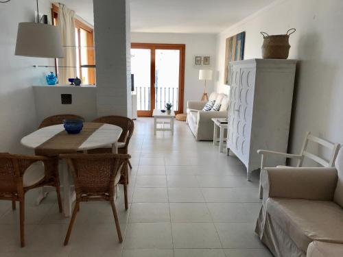 een woonkamer met een tafel en stoelen bij Port Pollensa Pins Apartment sea view in Port de Pollença