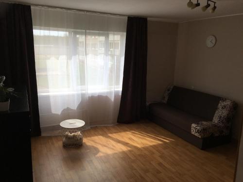sala de estar con sofá y ventana en sunny apartment, en Ventspils