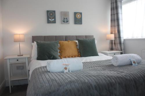 a bedroom with a bed with two pillows on it at Berwicks House - NEC & Airport - Stylish 3-bed house with garden in Birmingham