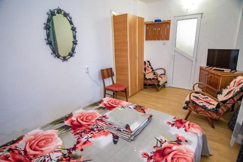 a room with a bed with pink roses on it at Old House in Vama Veche