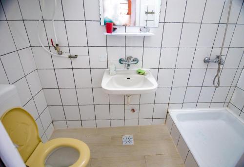 a bathroom with a yellow toilet and a sink at Old House in Vama Veche