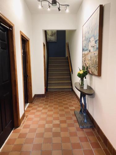 a hallway with stairs and a table and a painting at Sylvan Valley Lodge and Cellars in Sautee Nacoochee