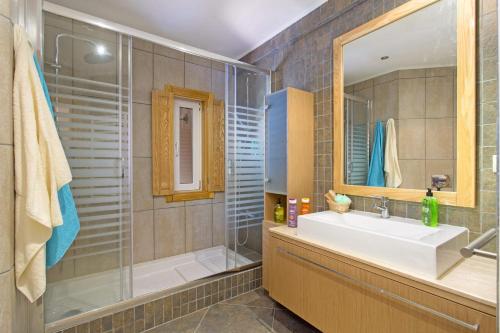 a bathroom with a sink and a shower and a mirror at Villa Falesia Mar by Villa Plus in Olhos de Água