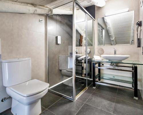 a bathroom with a toilet and a sink at Hotel La Fonda De La Estación in La Puebla de Valverde