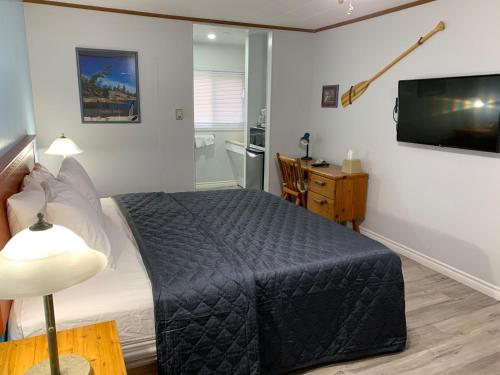 a bedroom with a bed and a flat screen tv at Town & Country Motel in Parry Sound