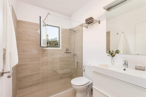 a white bathroom with a toilet and a sink at Villa Pins Ciutadella by Villa Plus in Cala Blanca