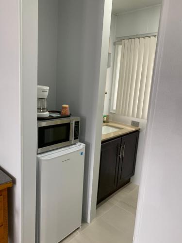 a small kitchen with a microwave and a refrigerator at Town & Country Motel in Parry Sound